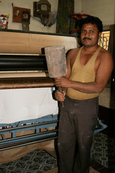 Calendaring machine and old fashioned mallet used to beat the silk