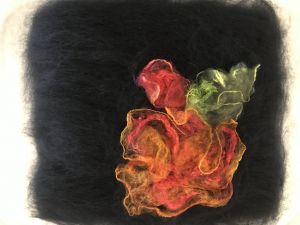 Ready for the felting machine--black merino wool with silk hankies, throwsters and rods creating the abstract flower