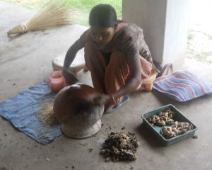 Dewangan tribal woman making Ghicha yarn, twisting the silk against the smooth back side of a pot